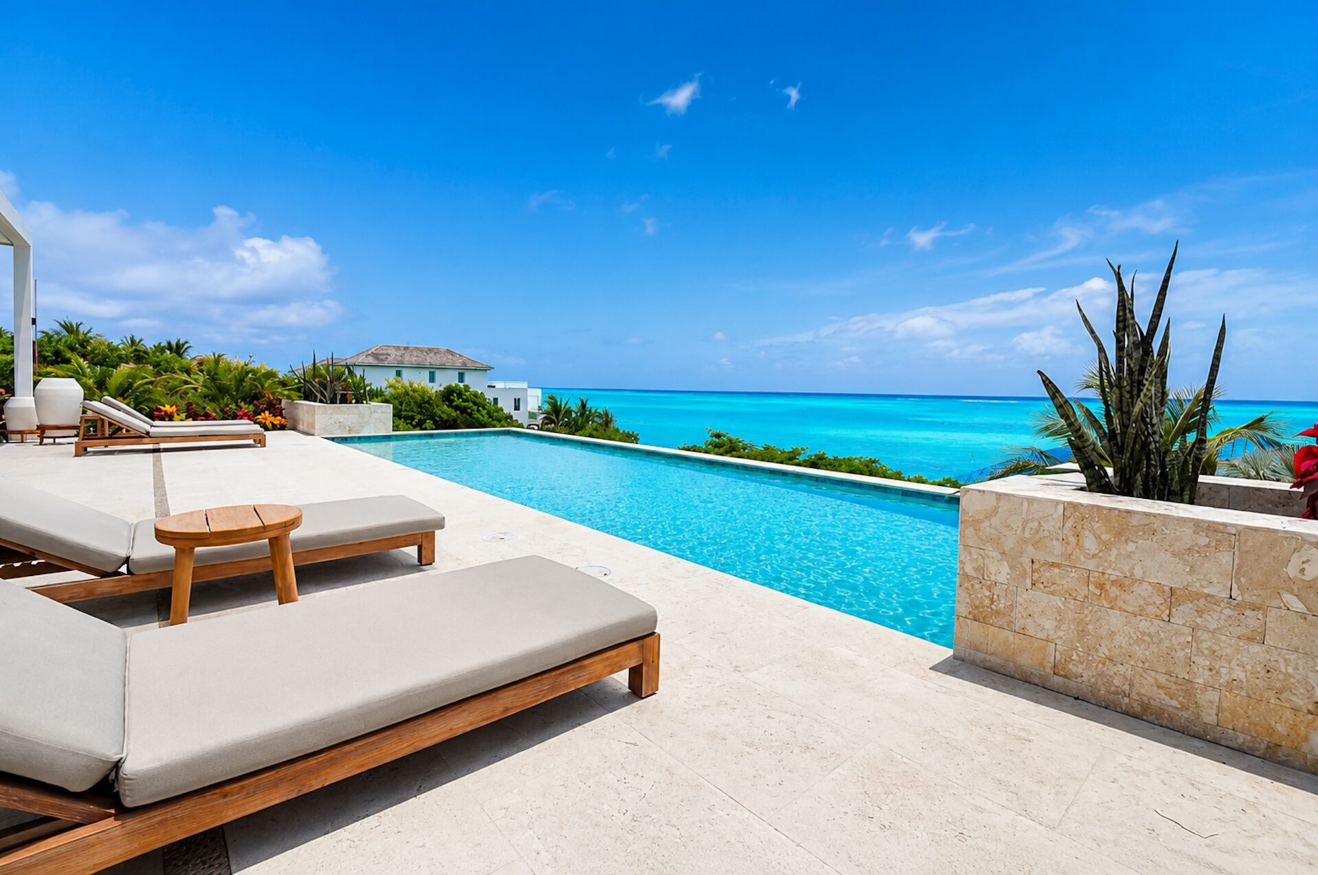 Infinity pool and loungers overlooking the ocean at a Turks and Caicos villa