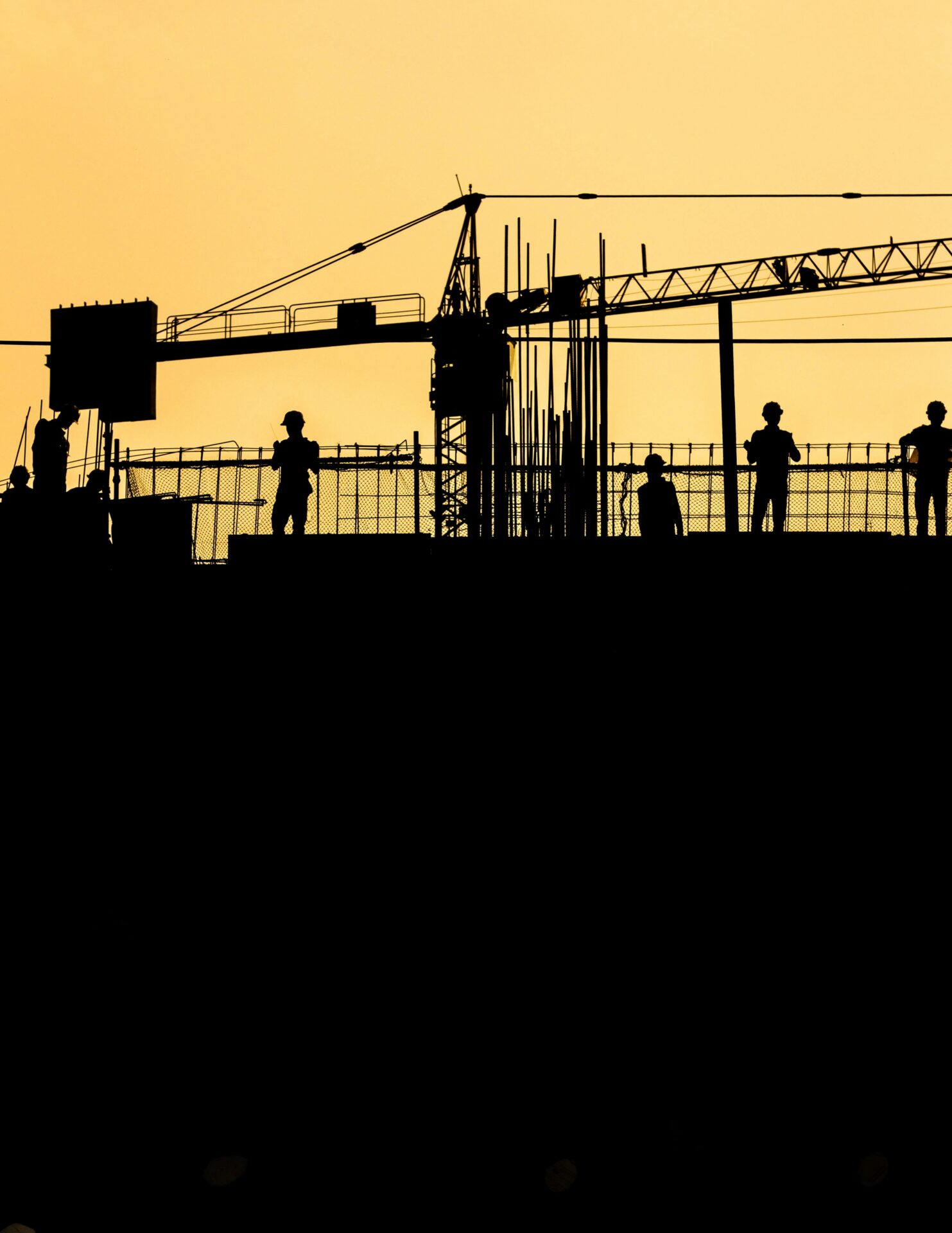 Construction crane silhouetted at sunset over a Providenciales development site